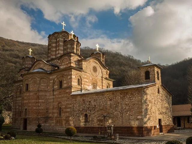 A historic monastery building with multiple domes and crosses against a cloudy sky.