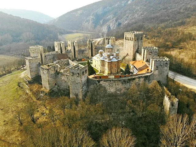 Aerial view of Manasija Monastery surrounded by fortified walls in a valley.