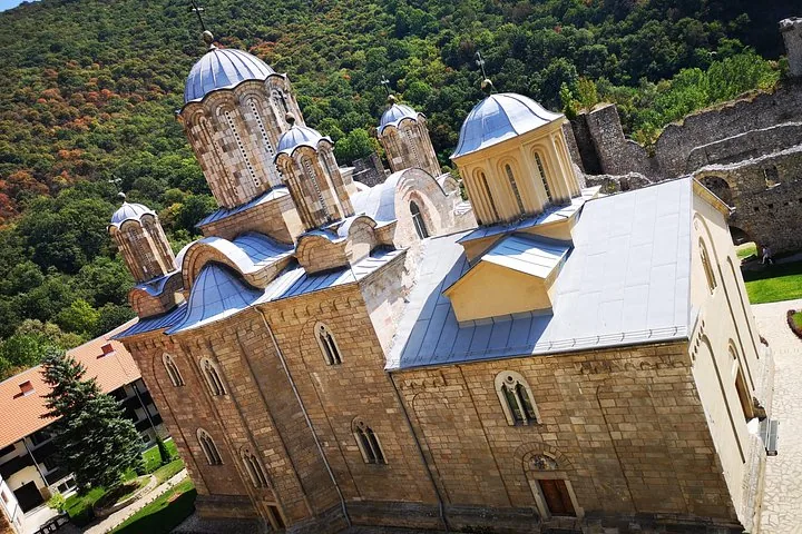 High angle shot of the domes of Manasija Monastery against forested hills.