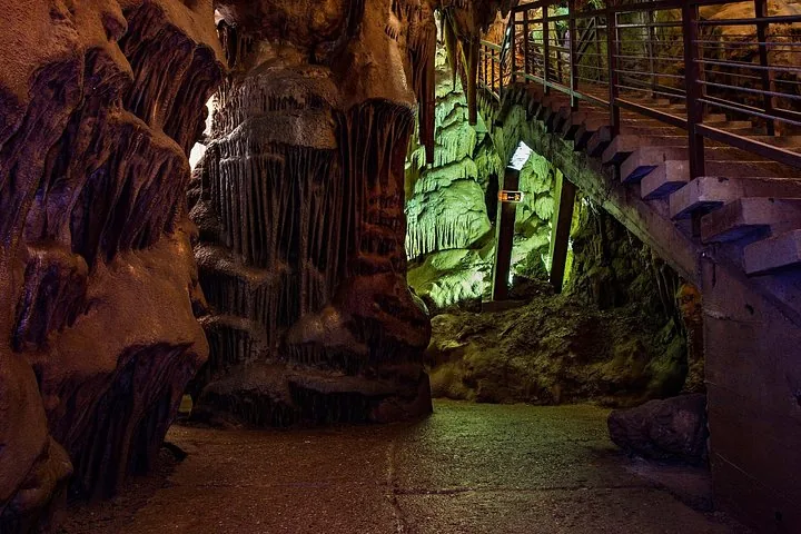 Beleuchteter Weg und Treppe, die sich durch Stalaktiten und Stalagmiten in der Resava-Höhle schlängeln.