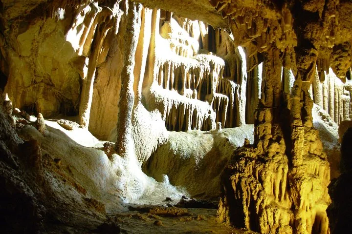 Interior of Resava Cave showcasing intricate stalactite and stalagmite rock formations illuminated by light.