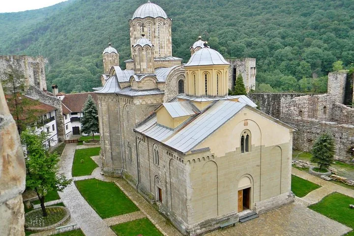 Aerial view of Manasija Monastery's church, surrounded by historic walls, gardens, and forested hills.